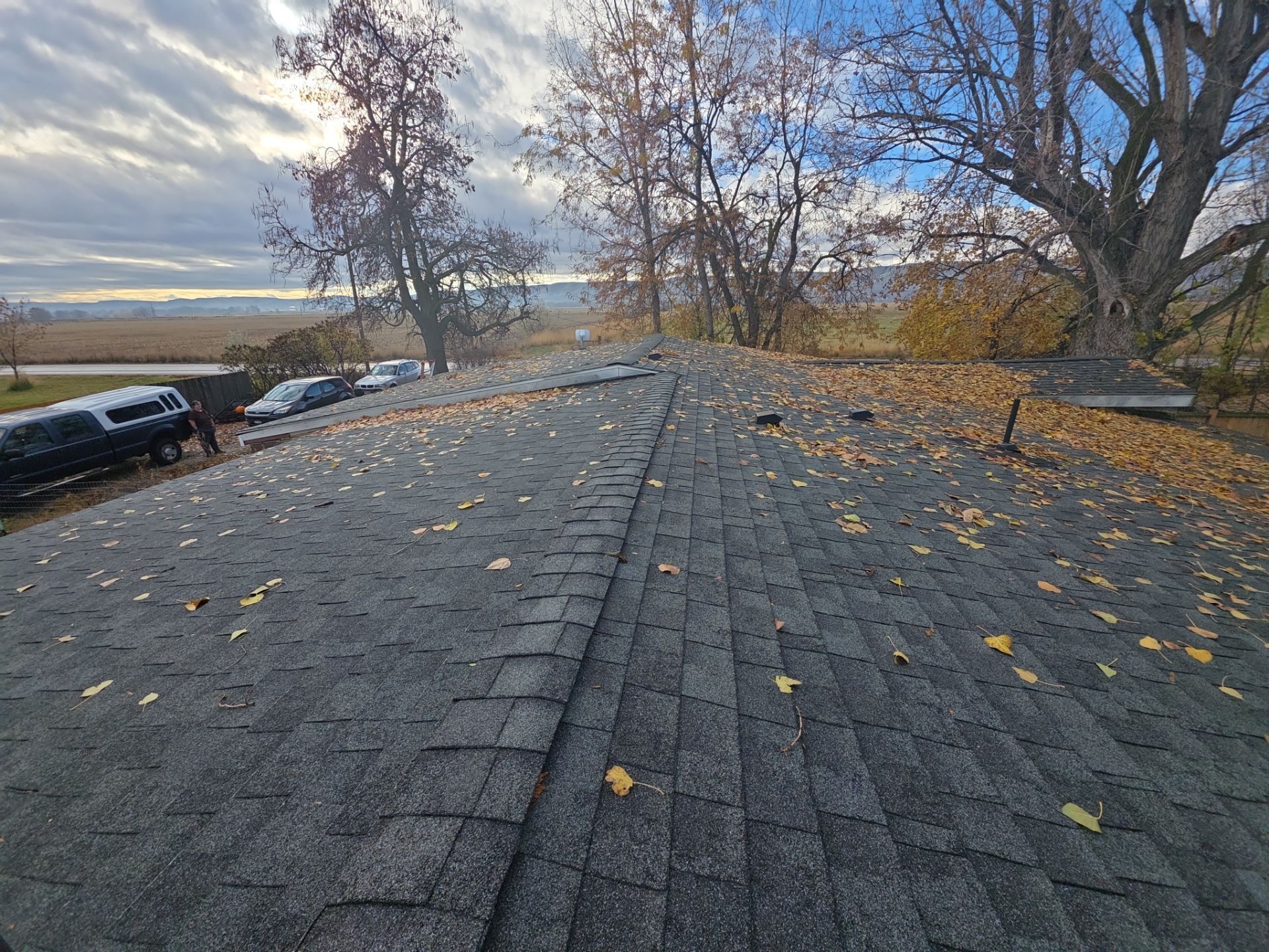 Roof ridge line view during inspection with autumn trees and Idaho sky