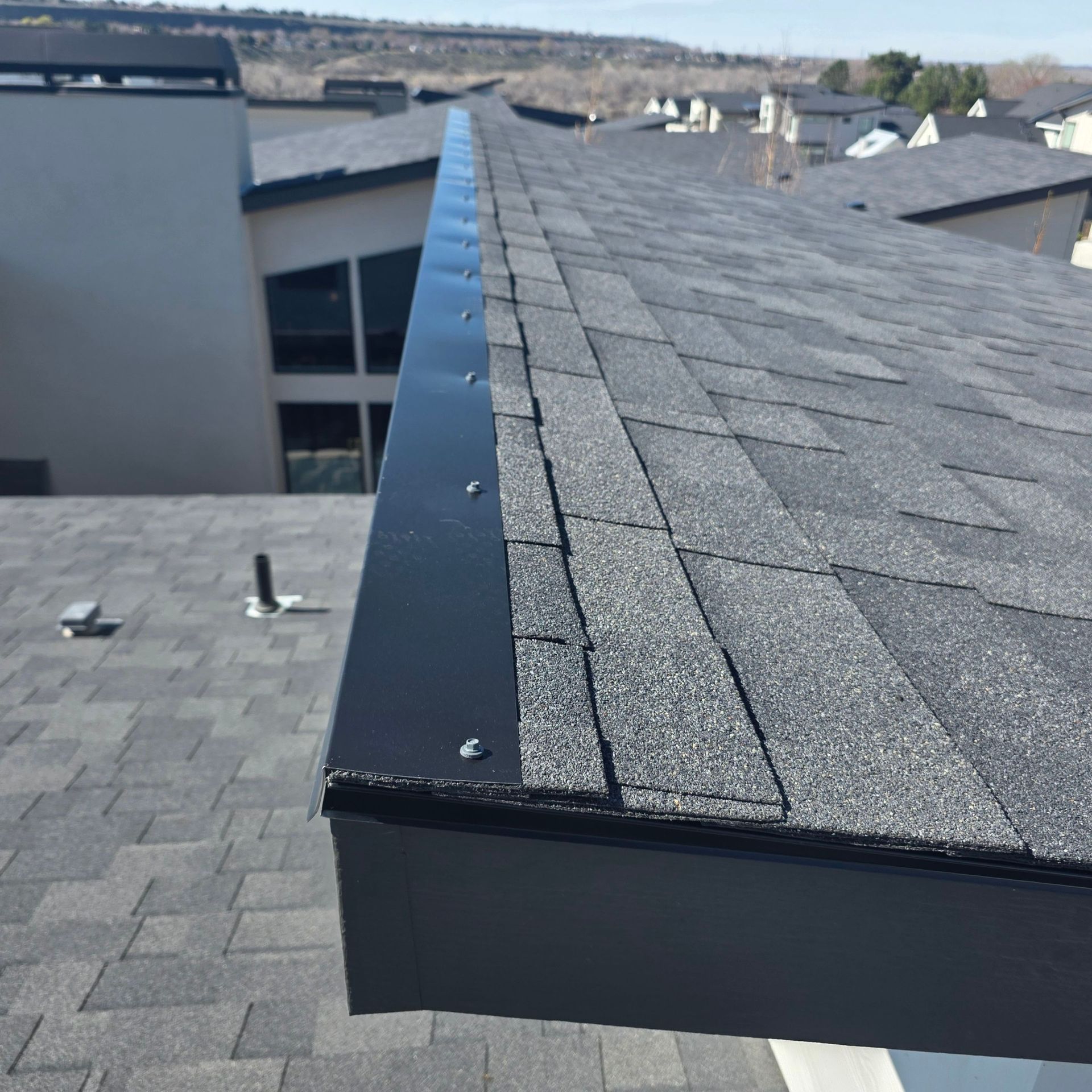 Completed roof replacement with clean edge flashing, Treasure Valley neighborhood in background